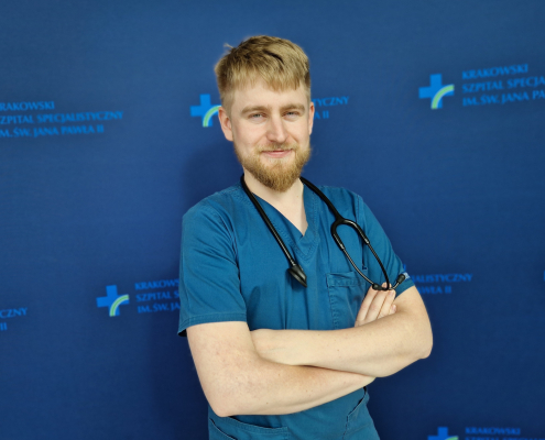 lek. kacper milcznowski w medycznym ubraniu na granatowym tle