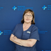 mgr Małgorzata Barnaś w medycznym ubraniu na granatowym tle