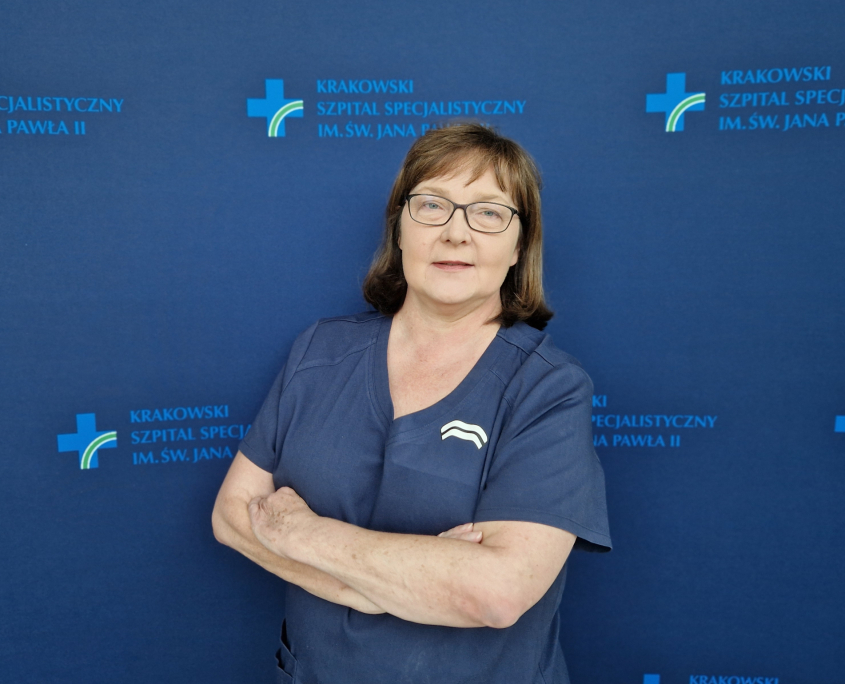 mgr Małgorzata Barnaś w medycznym ubraniu na granatowym tle