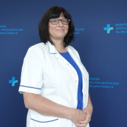 Lek. Marta Węgrzynowska w medycznym ubraniu na granatowym tle