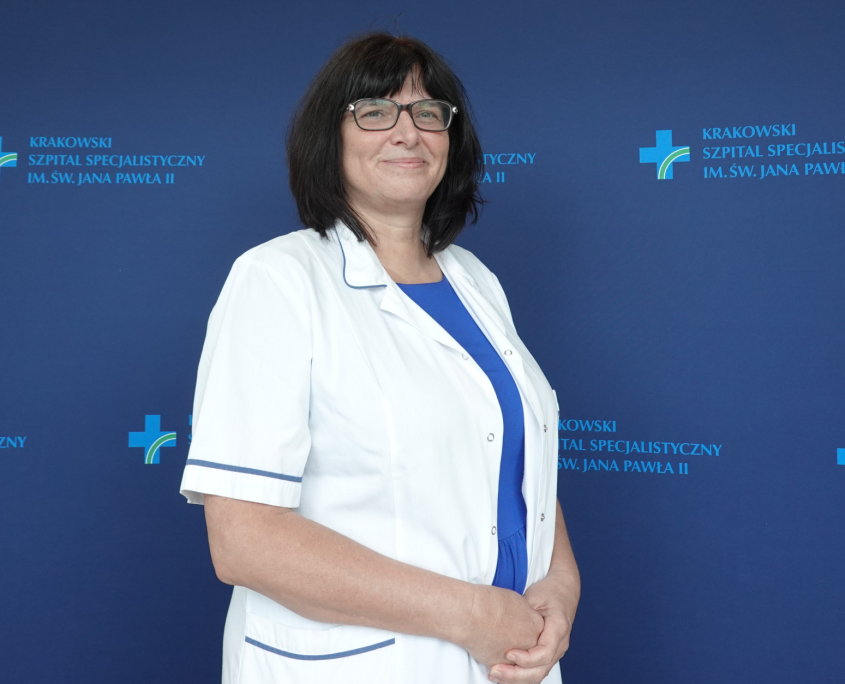 Lek. Marta Węgrzynowska w medycznym ubraniu na granatowym tle