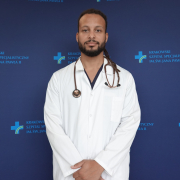 lek. David Mbeda w medycznym ubraniu na granatowym tle