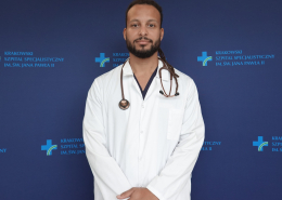 lek. David Mbeda w medycznym ubraniu na granatowym tle