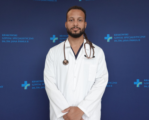 lek. David Mbeda w medycznym ubraniu na granatowym tle