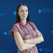 lek. Klaudia Bielecka w medycznym ubraniu na granatowym tle