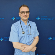 prof. dr hab. n. med. Grzegorz Kopeć w medycznym ubraniu na granatowym tle