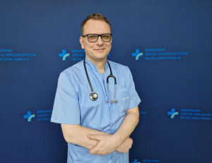 prof. dr hab. n. med. Grzegorz Kopeć w medycznym ubraniu na granatowym tle