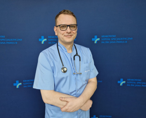 prof. dr hab. n. med. Grzegorz Kopeć w medycznym ubraniu na granatowym tle