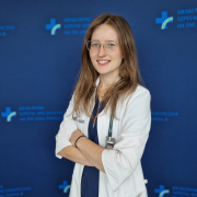 lek. Aleksandra Wozniak w medycznym ubraniu na granatowym tle