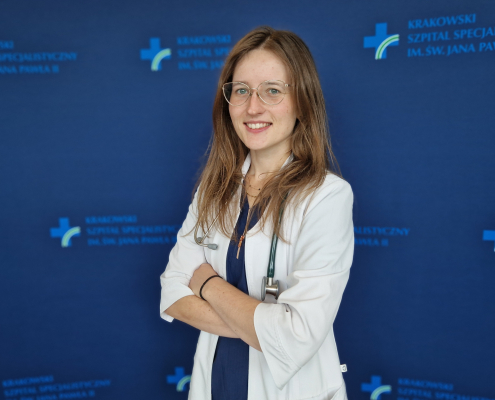 lek. Aleksandra Wozniak w medycznym ubraniu na granatowym tle