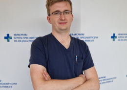 lek. Karol Nowak w medycznym ubraniu na białym tle