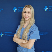 Lek. Natalia Matyjewicz w medycznym ubraniu na granatowym tle