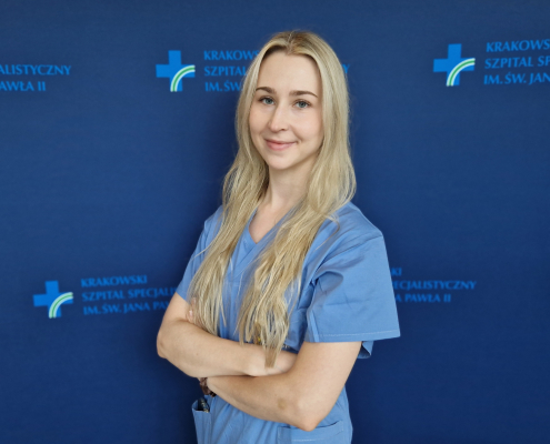 Lek. Natalia Matyjewicz w medycznym ubraniu na granatowym tle