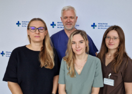 Cztery osoby na tle logotypów szpitala.