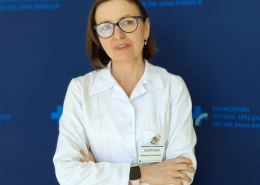 mgr Małgorzata Grudniewska w medycznym ubraniu na granatowym tle