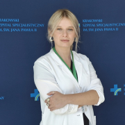 mgr Paulina Tomsia w medycznym ubraniu na granatowym tle