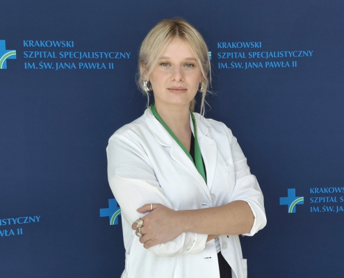 mgr Paulina Tomsia w medycznym ubraniu na granatowym tle