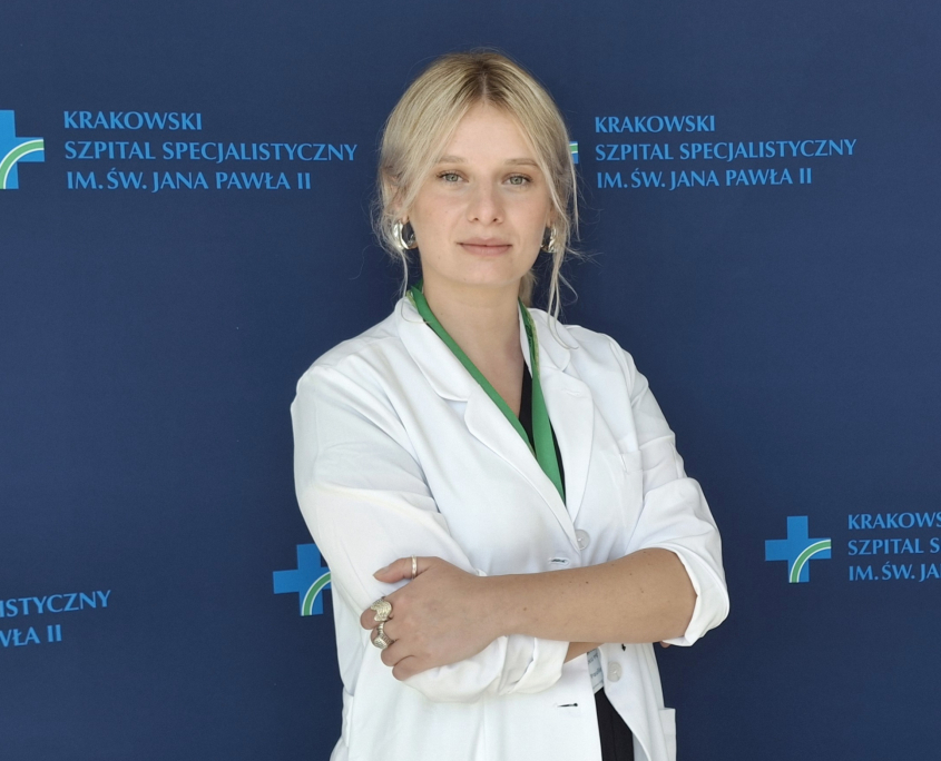 mgr Paulina Tomsia w medycznym ubraniu na granatowym tle