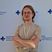 lek. med. Konrad Jesiołowski w medycznym ubraniu na białym tle