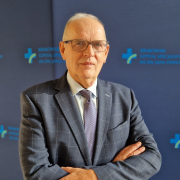 prof. dr hab. n. med. Piotr Podolec w marynarce na granatowym tle