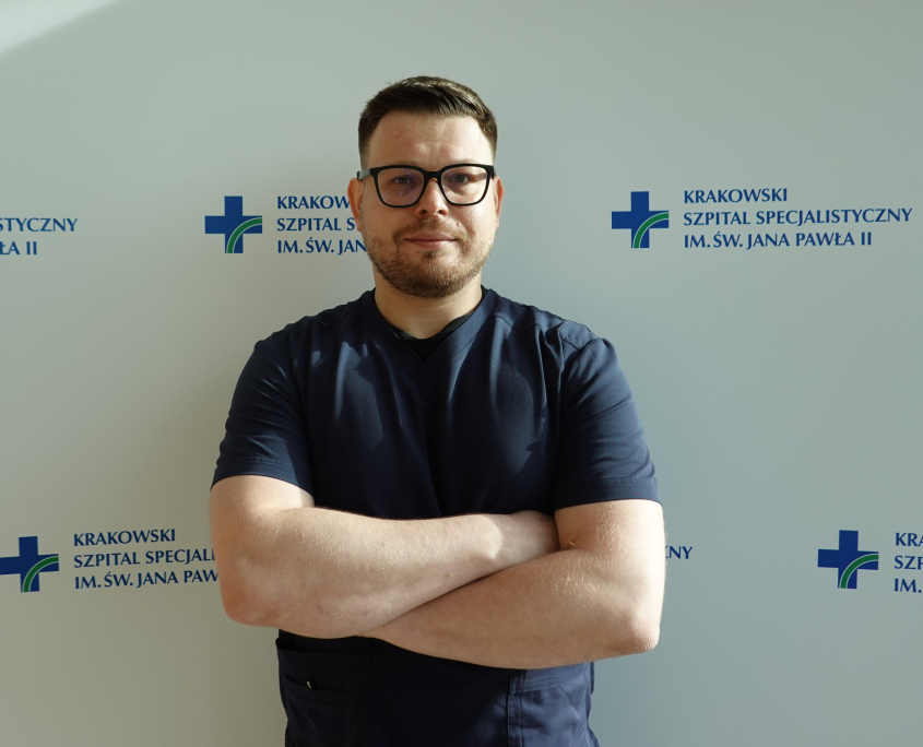 lek. Karol Mazur w medycznym ubraniu na białym tle