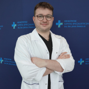 mgr Piotr Rutkowski w medycznym ubraniu na granatowym tle