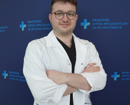 mgr Piotr Rutkowski w medycznym ubraniu na granatowym tle