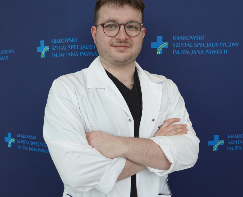 mgr Piotr Rutkowski w medycznym ubraniu na granatowym tle