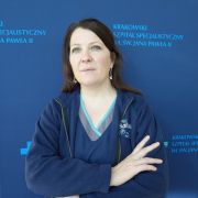 dr n. społ. Anna Wójcik w medycznym ubraniu na granatowym tle