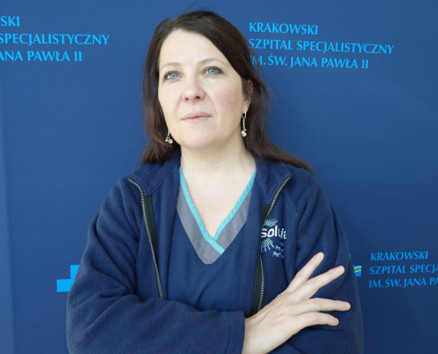 dr n. społ. Anna Wójcik w medycznym ubraniu na granatowym tle