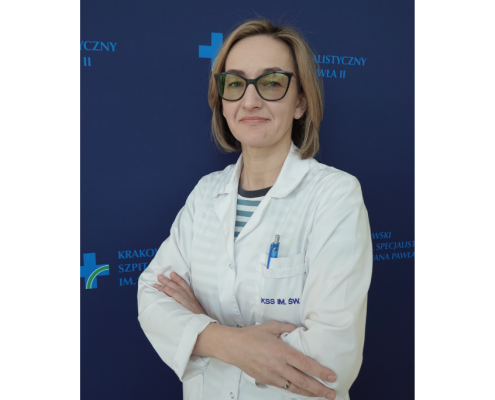 mgr Karolina Tolińska w medycznym ubraniu na granatowym tle