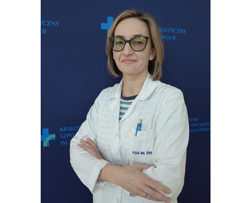 mgr Karolina Tolińska w medycznym ubraniu na granatowym tle