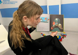 Wolontariuszka Fundacji podczas czytania dzieciom książki.