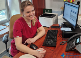 Dr E. Dobrowolska w gabinecie przy biurku podczas pracy w poradni.