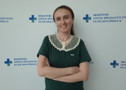 Dr Michno na tle ścianki z logotypem szpitala.