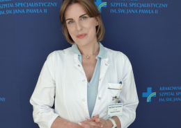 Dr hab. n. med. Magdalena Kopytek an tle granatowej ścianki z logotypem Szpitala.