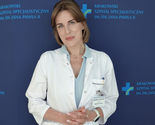 Dr hab. n. med. Magdalena Kopytek an tle granatowej ścianki z logotypem Szpitala.