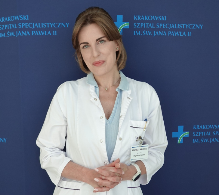 Dr hab. n. med. Magdalena Kopytek an tle granatowej ścianki z logotypem Szpitala.
