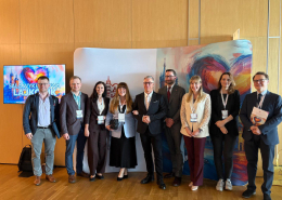 Kolorowe zdjęcie grupowe na tle grafiki związanej z konferencją Asocjacji Niewydolności Serca PTK.