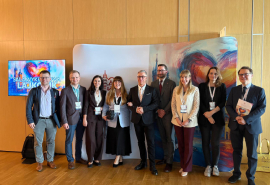Kolorowe zdjęcie grupowe na tle grafiki związanej z konferencją Asocjacji Niewydolności Serca PTK.