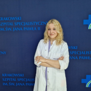 Psycholog Urszula Kaleta na tle granatowej ścianki do zdjęć z logotypami Szpitala.