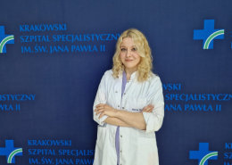 Psycholog Urszula Kaleta na tle granatowej ścianki do zdjęć z logotypami Szpitala.