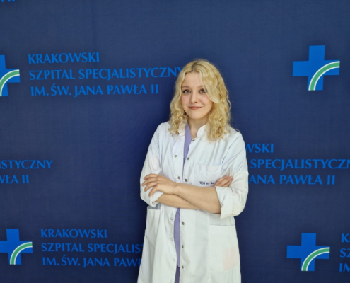 Psycholog Urszula Kaleta na tle granatowej ścianki do zdjęć z logotypami Szpitala.