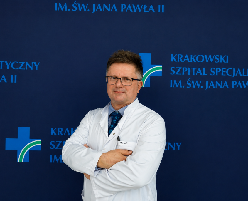 Dr Mirosław Nęcki na tle ścianki z logotypem szpitala.