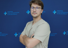 lek. Kamil Marzec w medycznym ubraniu na granatowym tle