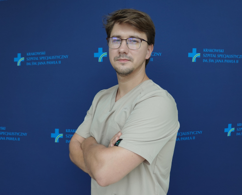 lek. Kamil Marzec w medycznym ubraniu na granatowym tle