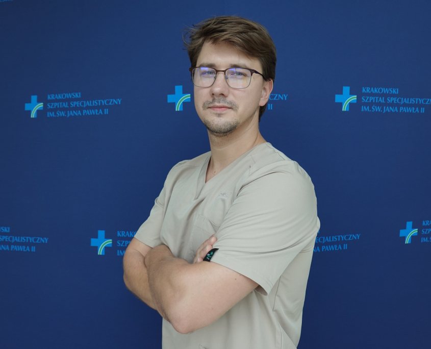 lek. Kamil Marzec w medycznym ubraniu na granatowym tle